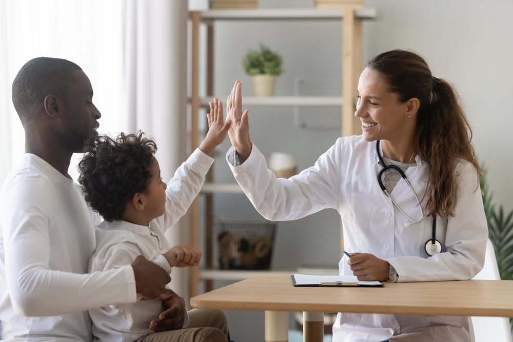 Featured image showing a father and son high fiving a doctor in a modern hospital room.